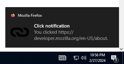 Example notification on Windows 10, located above the system clock, with a bold title reading "Click notification" followed by regular text reading "You clicked https://mdn.go-mizu.dev/vi/docs/MDN". The notification has a small Firefox logo in the top left corner that is followed by "Mozilla Firefox", and a link icon to the left of the primary notification text.